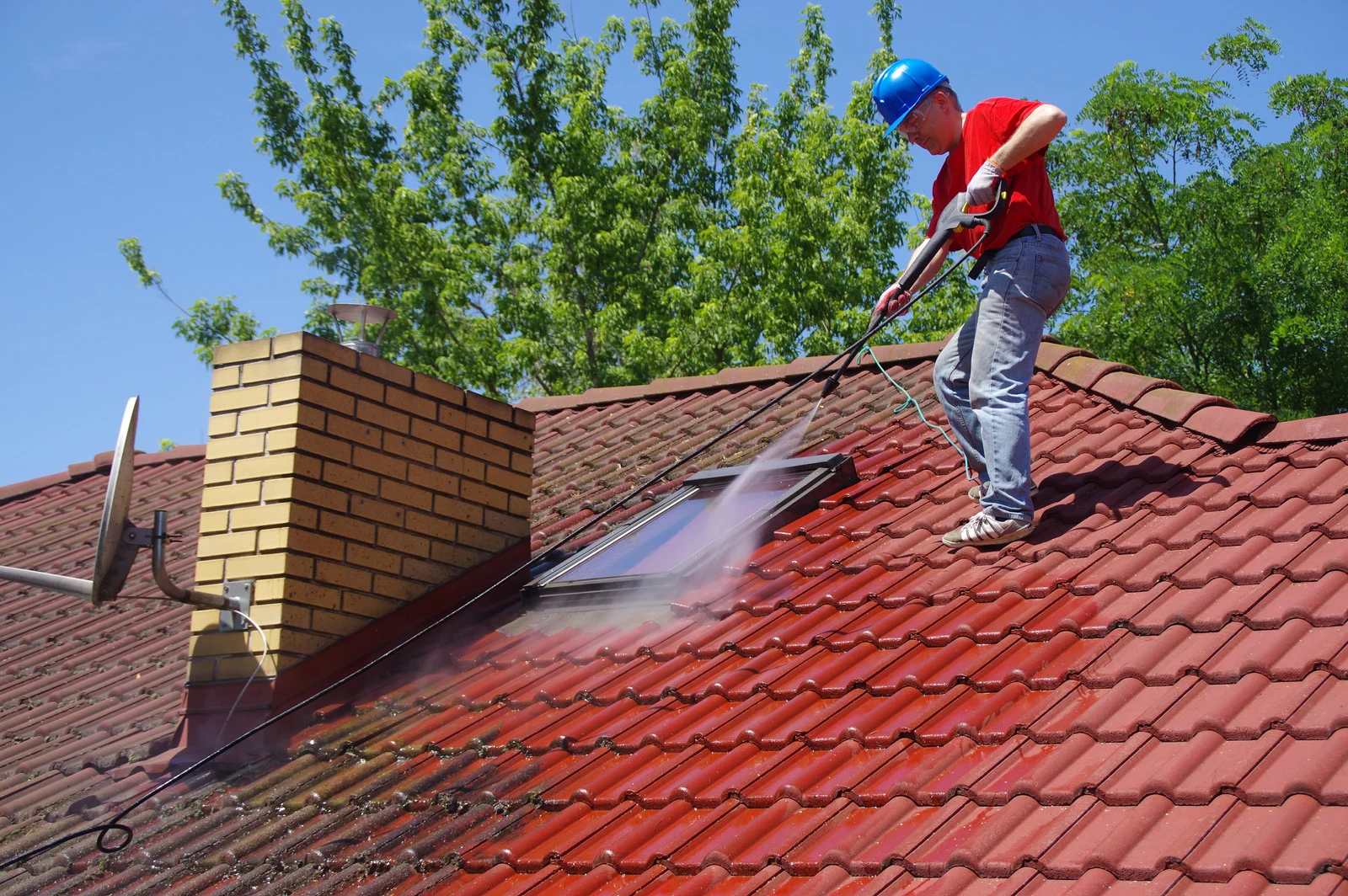 Roof cleaning treatment on moss-covered roof tiles
